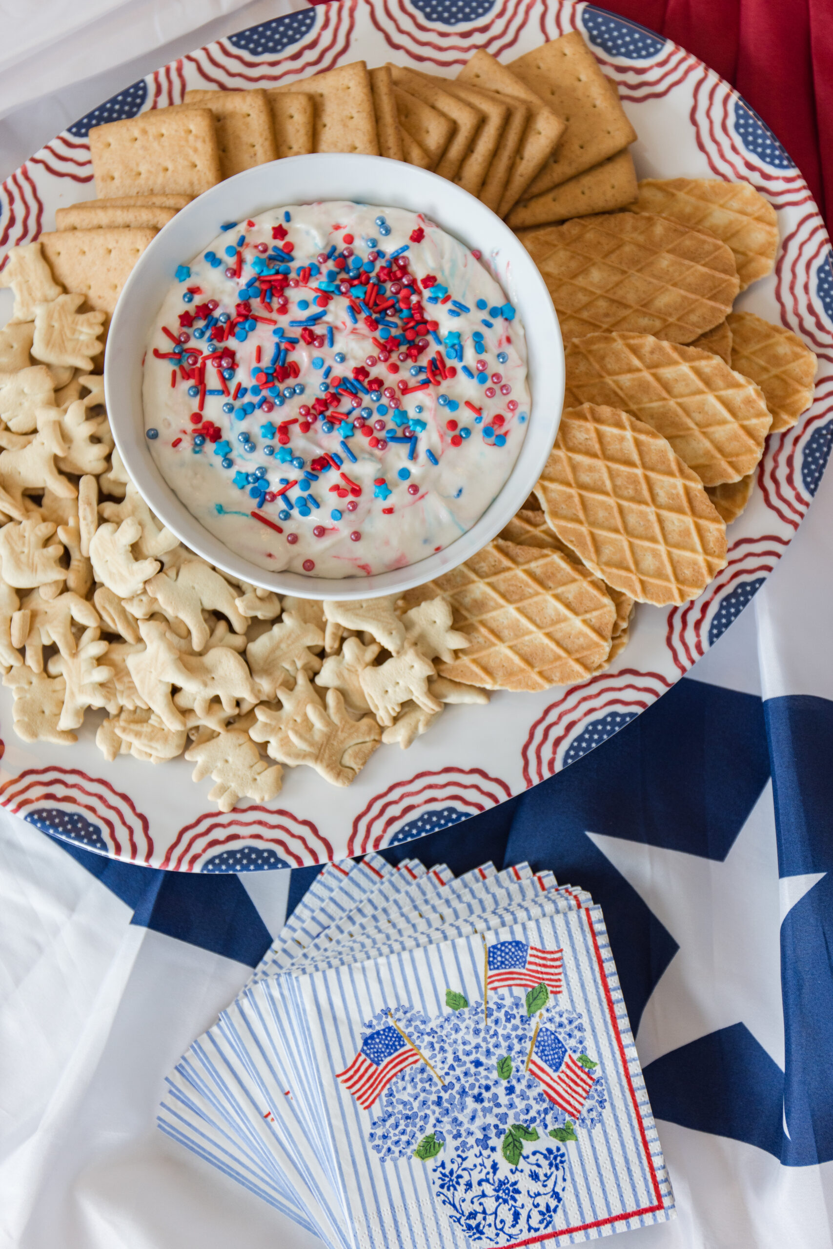 close up image of serving plate with snacks and serving bowl filled with dip for snacks and American flag cocktail napkins