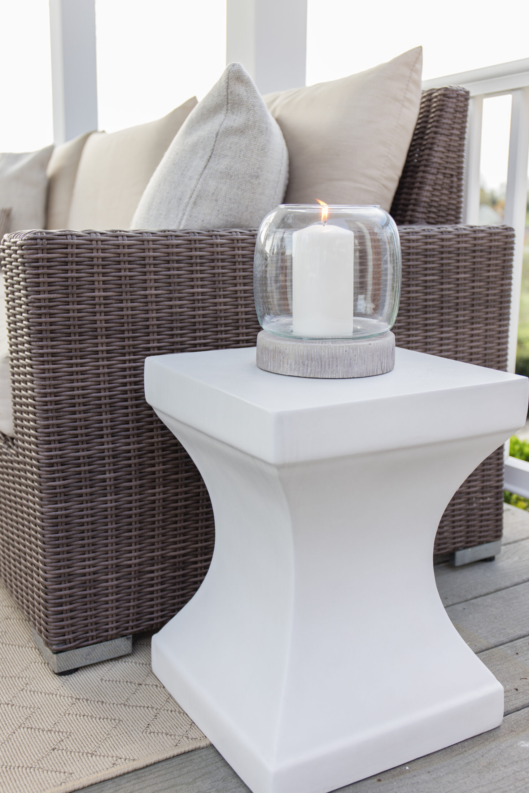the arched manor outdoor patio styling, white accent table styled with hurricane candleholder