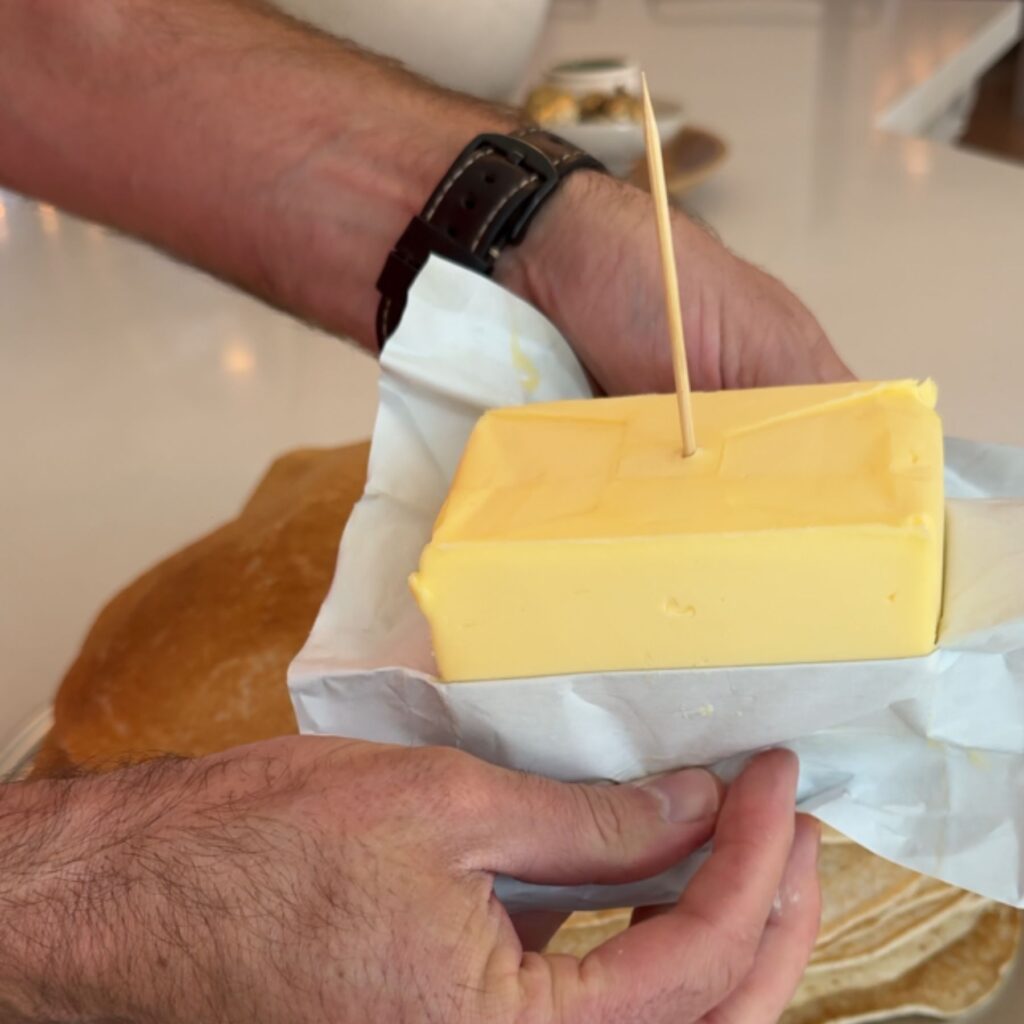 Use a toothpick to attach the block of butter to the top of the pancake stack