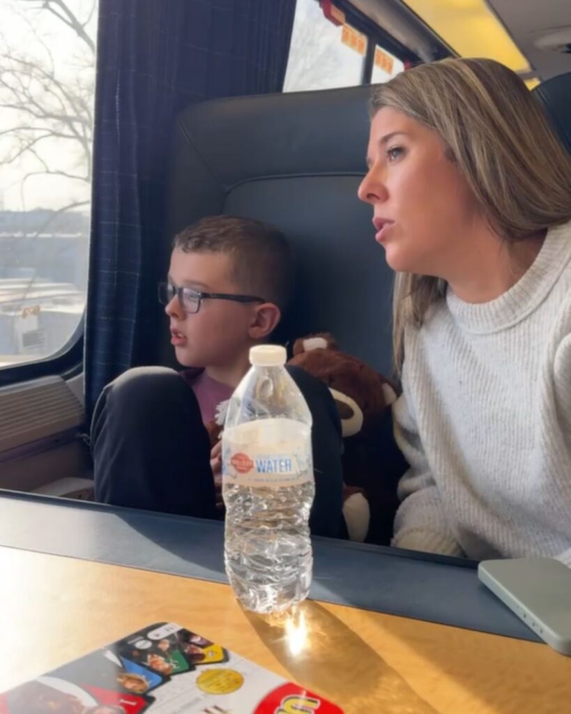Tristan and Megan at one side of the four person table on the Amtrak Accela.