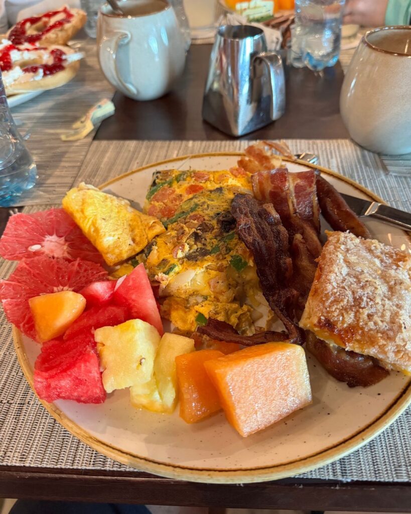 My morning breakfast plate featuring an omelet, bacon, and fresh fruit. Yum!