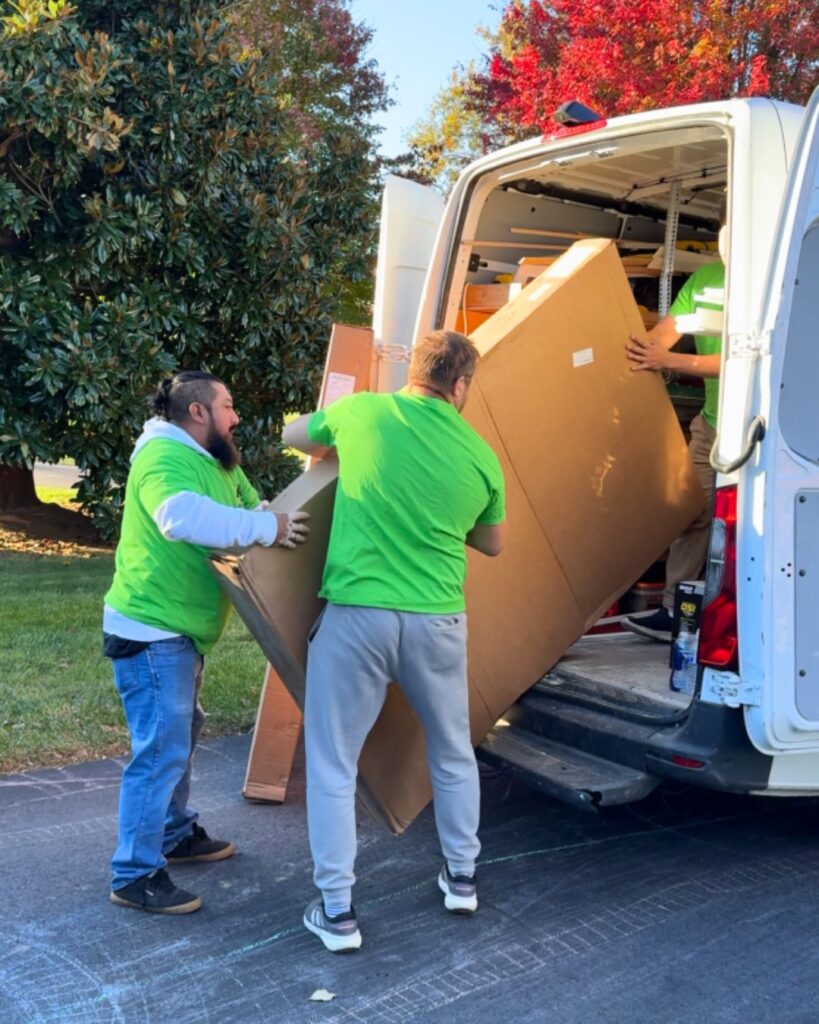 The crew unloading one of the windows from their van.